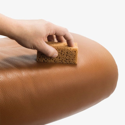 Stressless Leather Care Kit in use person is sponging the leather sofas
